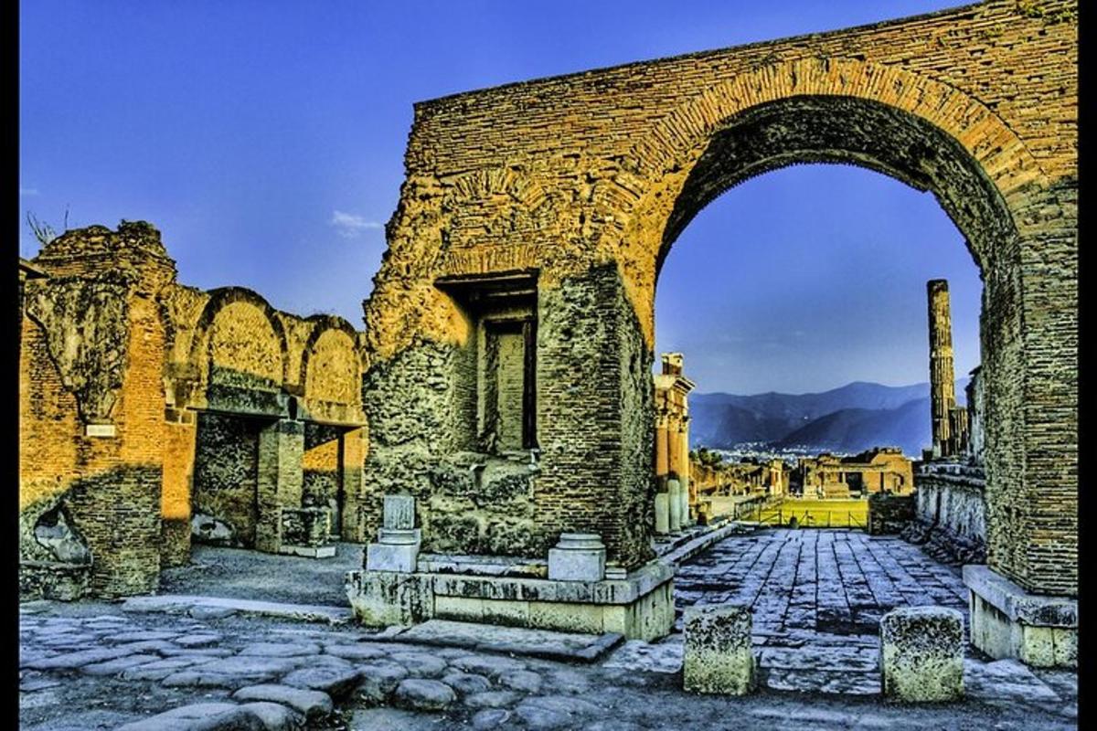 an old stone building with an arch in a city