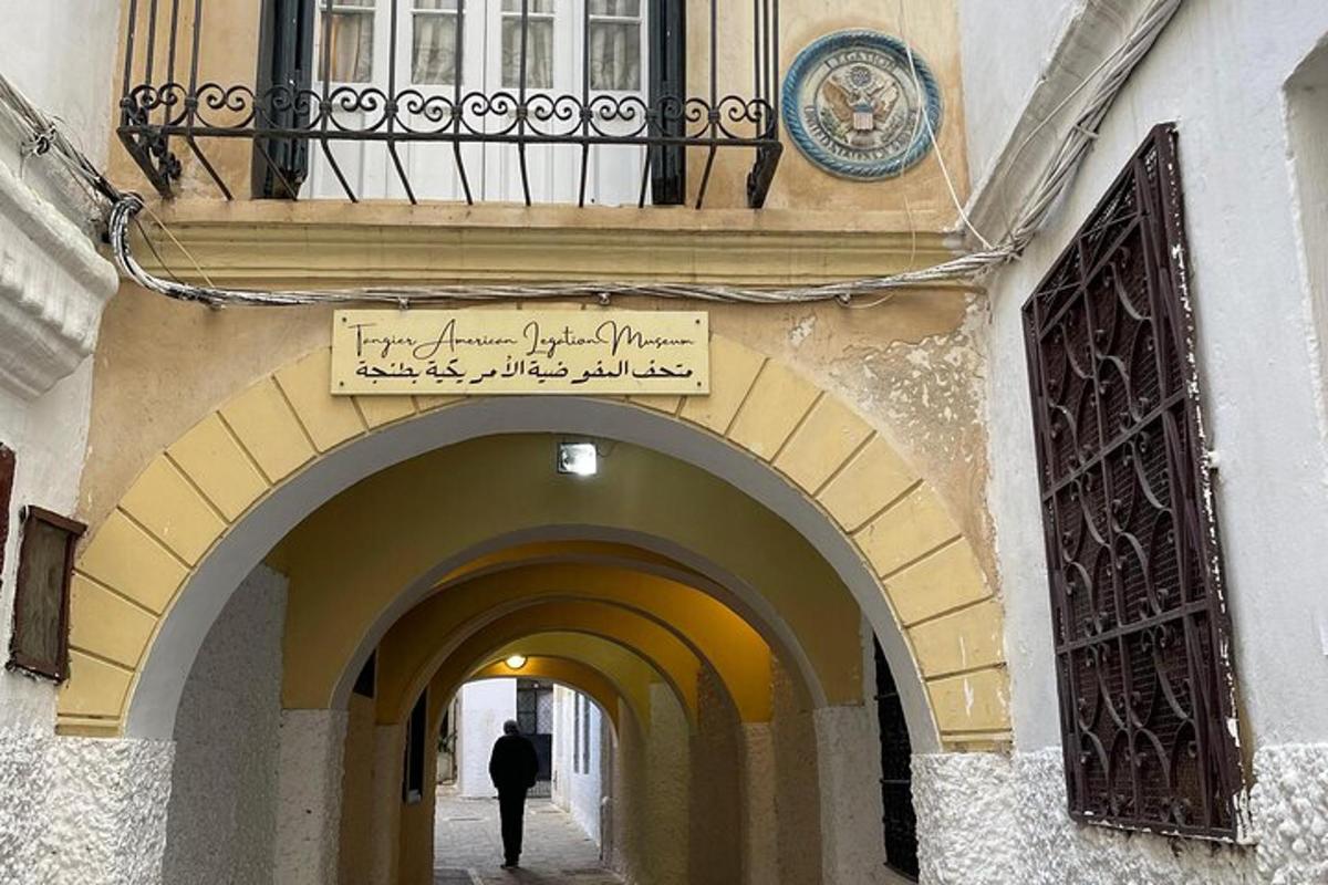 muž kráčející uličkou pod balkonem