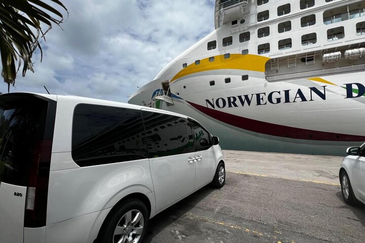 a white van parked in front of a cruise ship