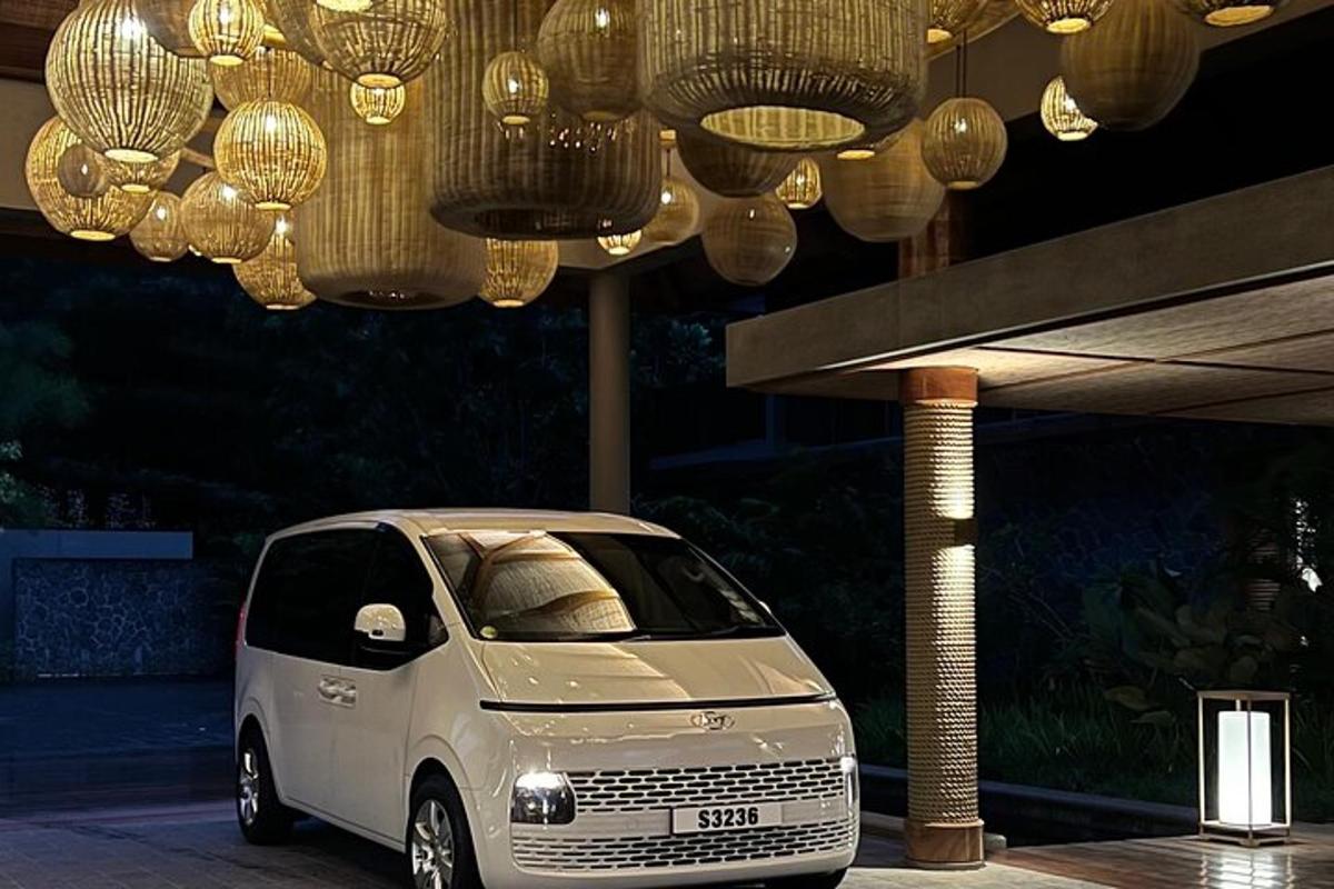 a small white car parked under chandeliers