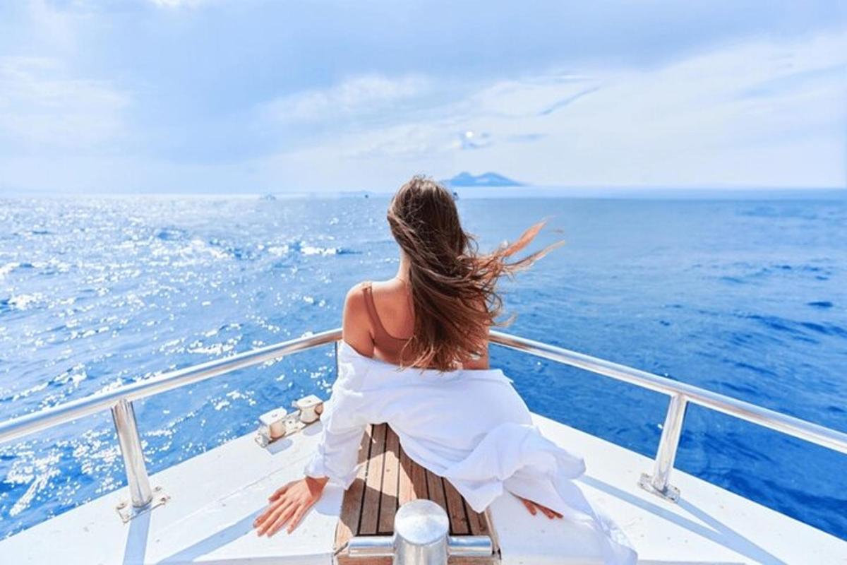 una donna seduta su una barca che guarda l'oceano