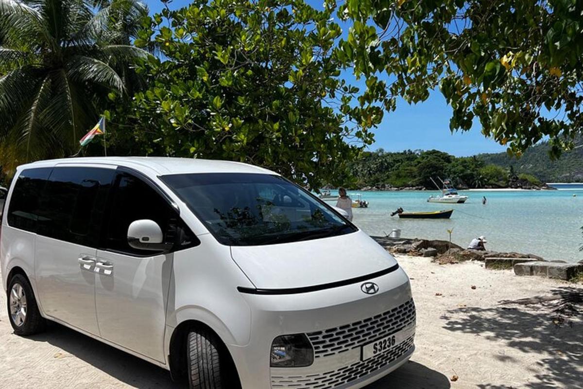 a white van parked on a beach near the water