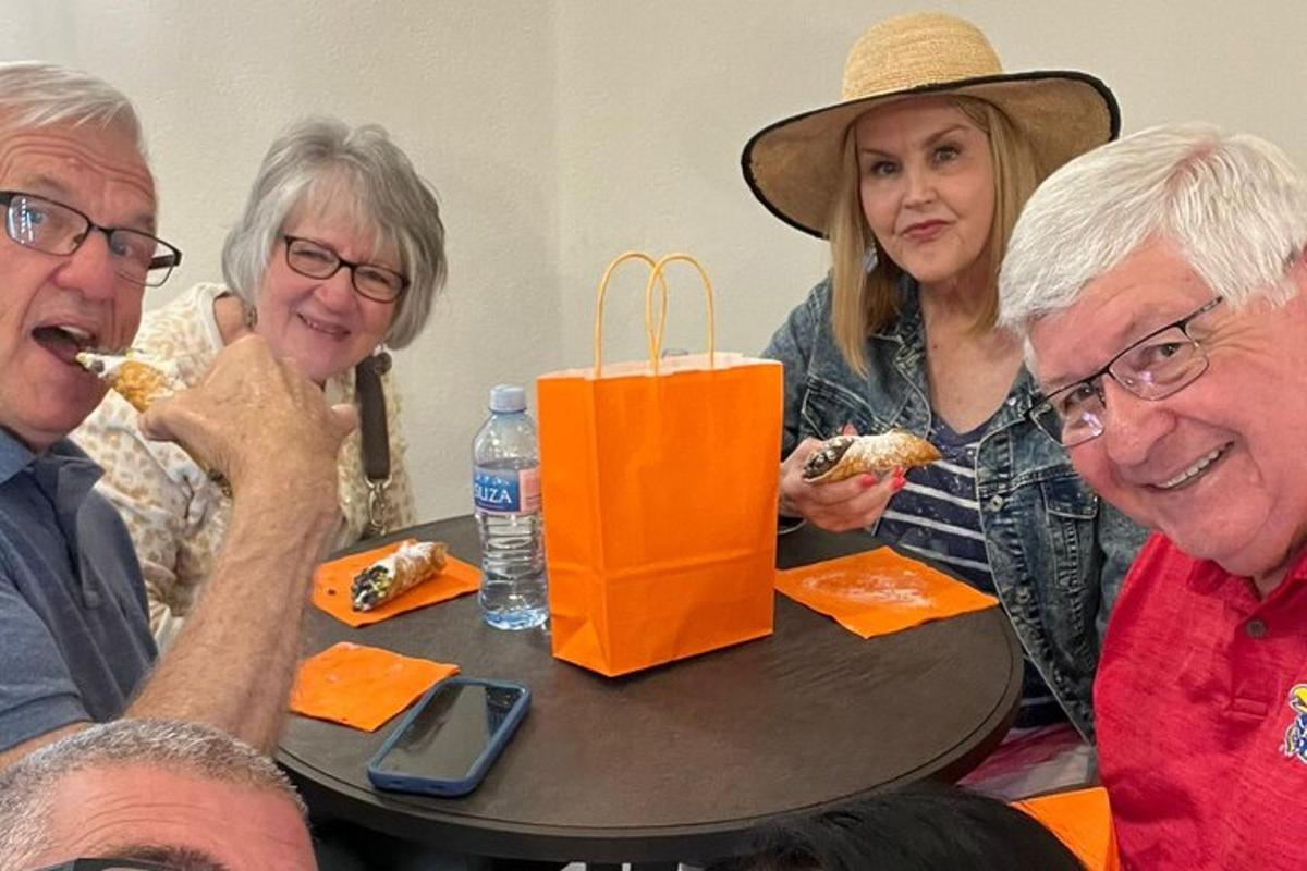 um grupo de pessoas sentadas ao redor de uma mesa comendo comida