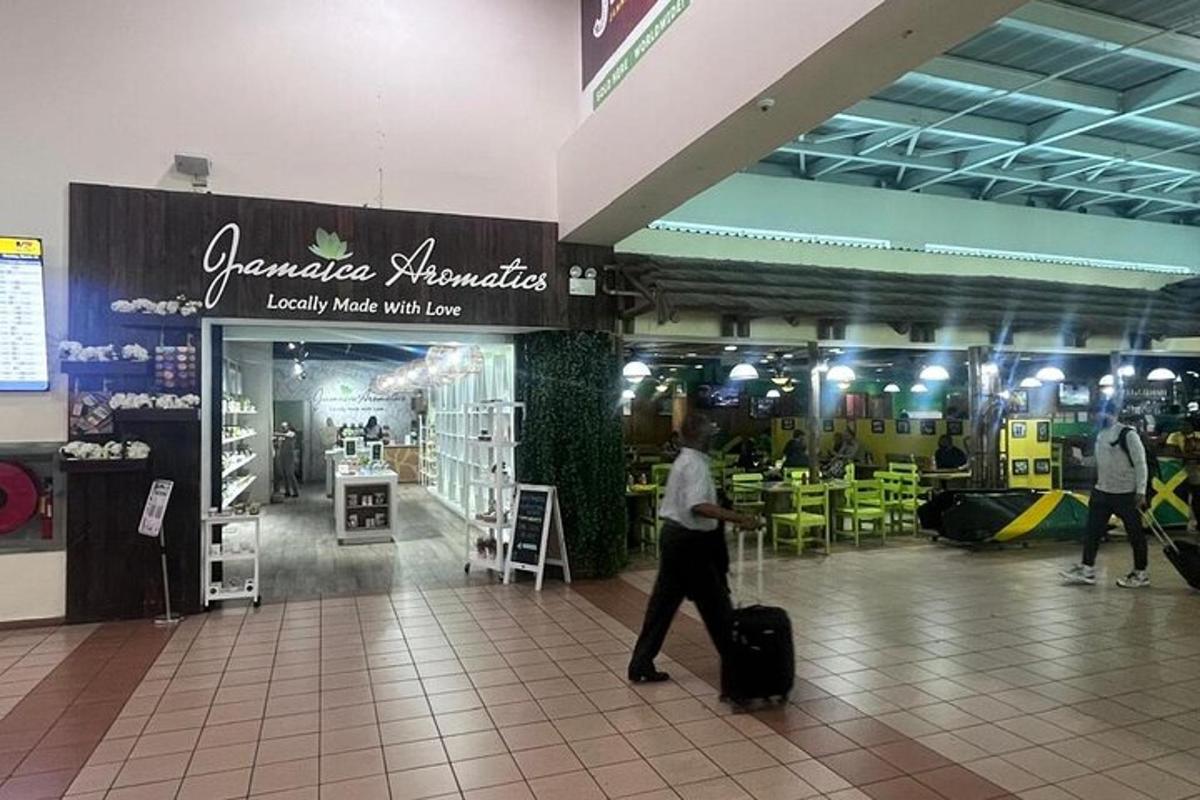 un uomo che cammina in un centro commerciale con i suoi bagagli