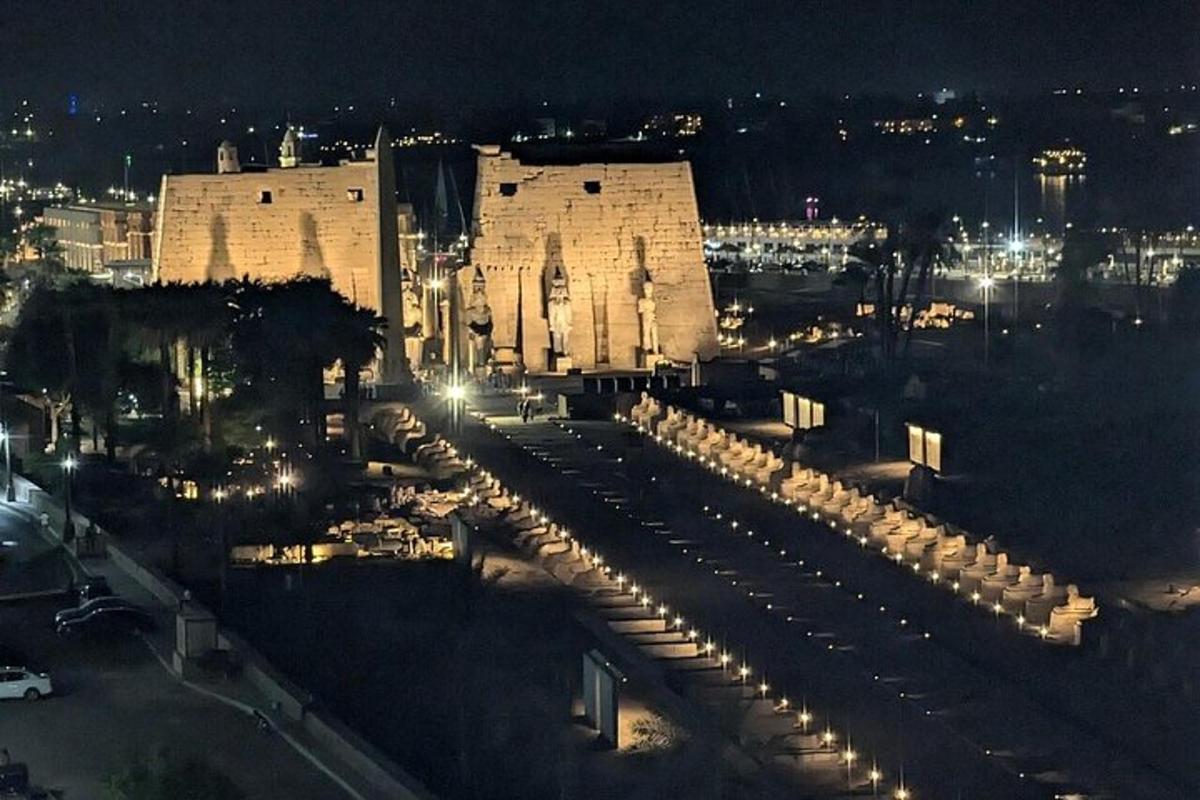 eine Stadt bei Nacht mit einem großen Gebäude mit Lichtern