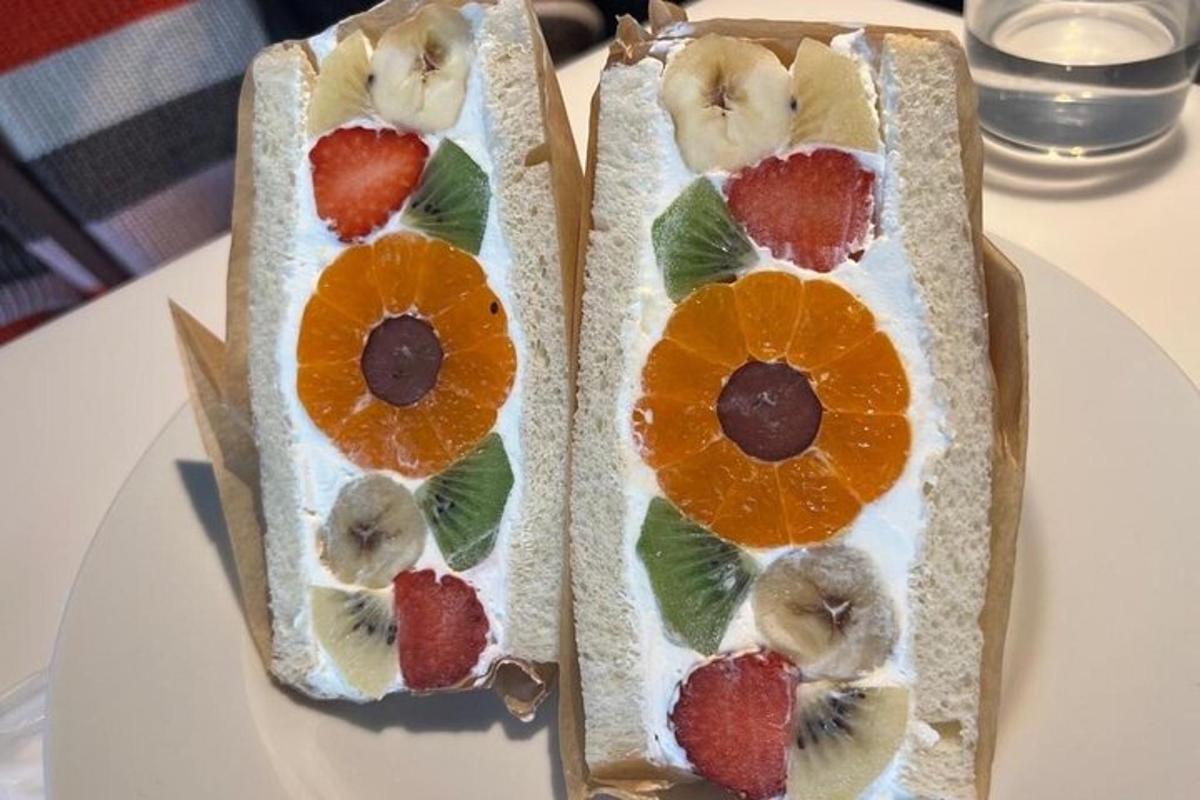 Dos sándwiches con fruta encima de una mesa.
