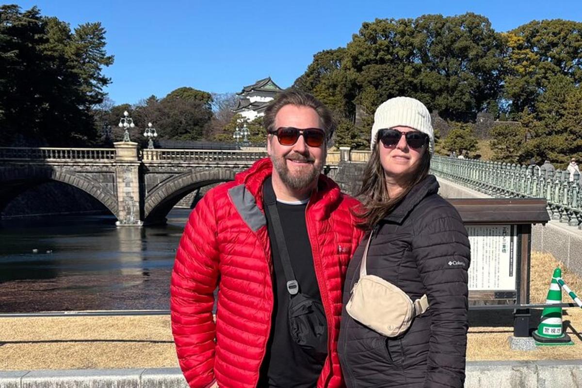 a man and a woman standing in front of a bridge
