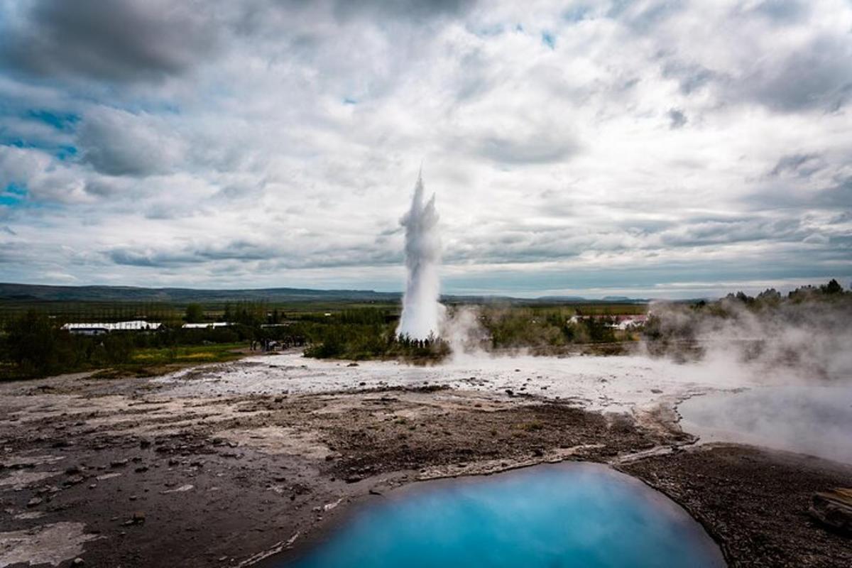 a geyser in the middle of a field with blue water