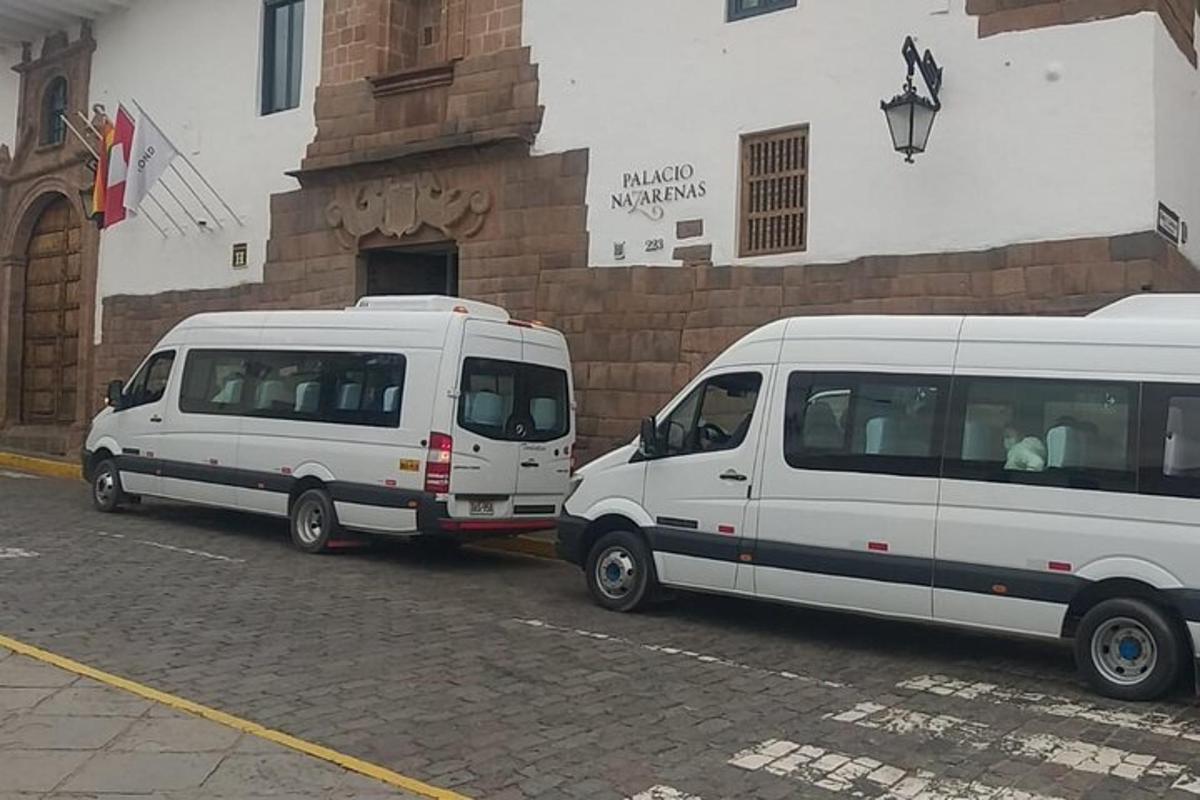 Dos furgonetas blancas estacionadas frente a un edificio
