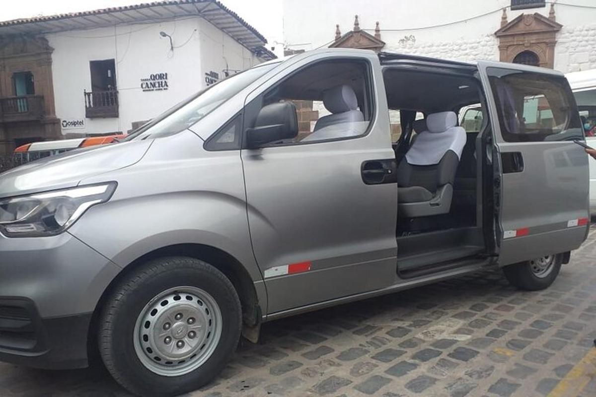 một chiếc xe tải màu bạc đỗ trong bãi đậu xe với cánh cửa mở