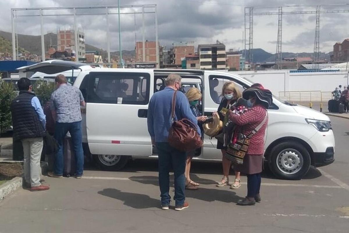 sekelompok orang berdiri di depan mobil van putih