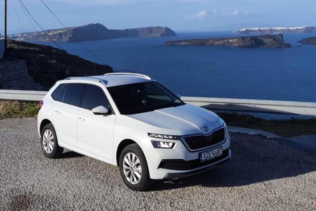 um carro branco estacionado em uma colina perto do oceano