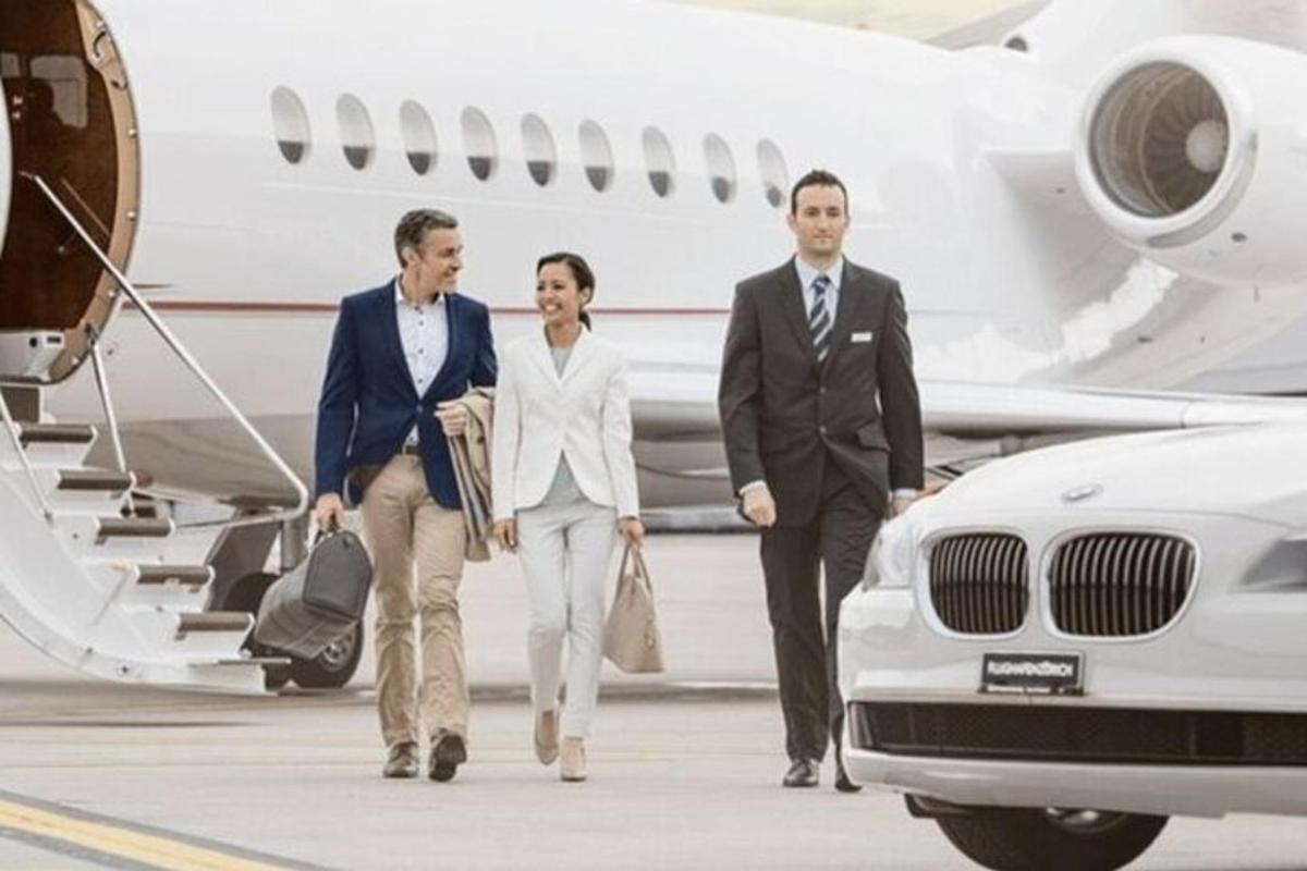 um grupo de três pessoas caminhando em direção a um avião