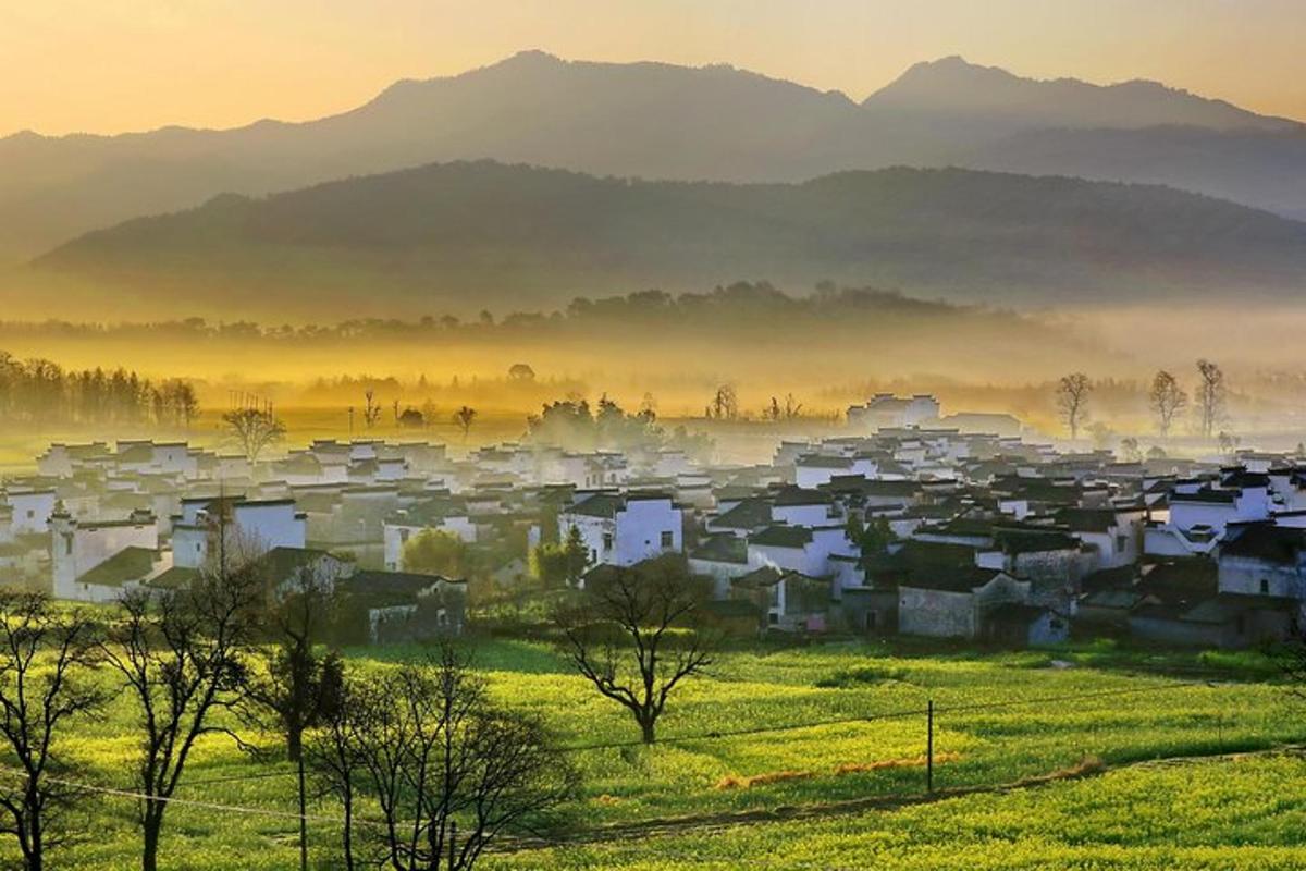 a small village in a field in the mountains