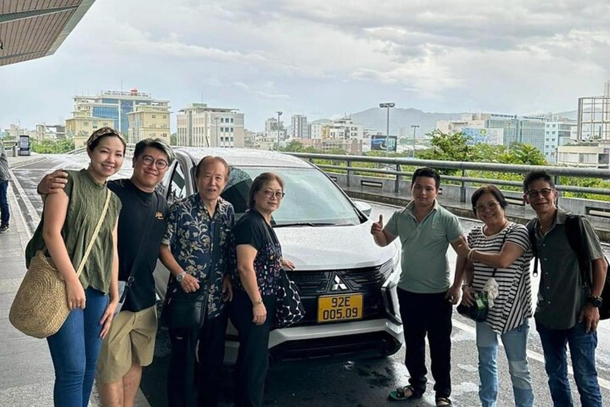 um grupo de pessoas em pé na frente de um carro