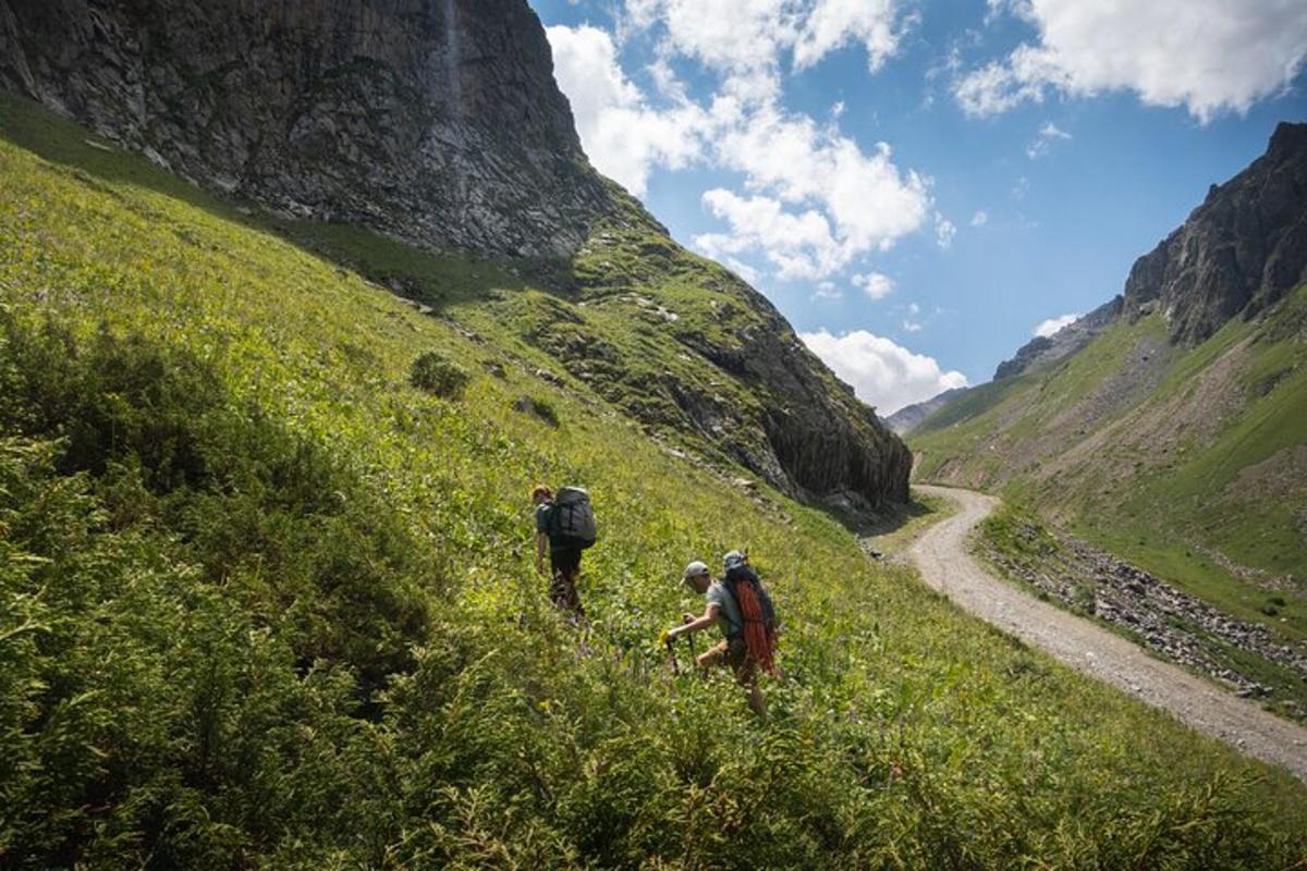 Tres personas caminando cuesta arriba por un sendero