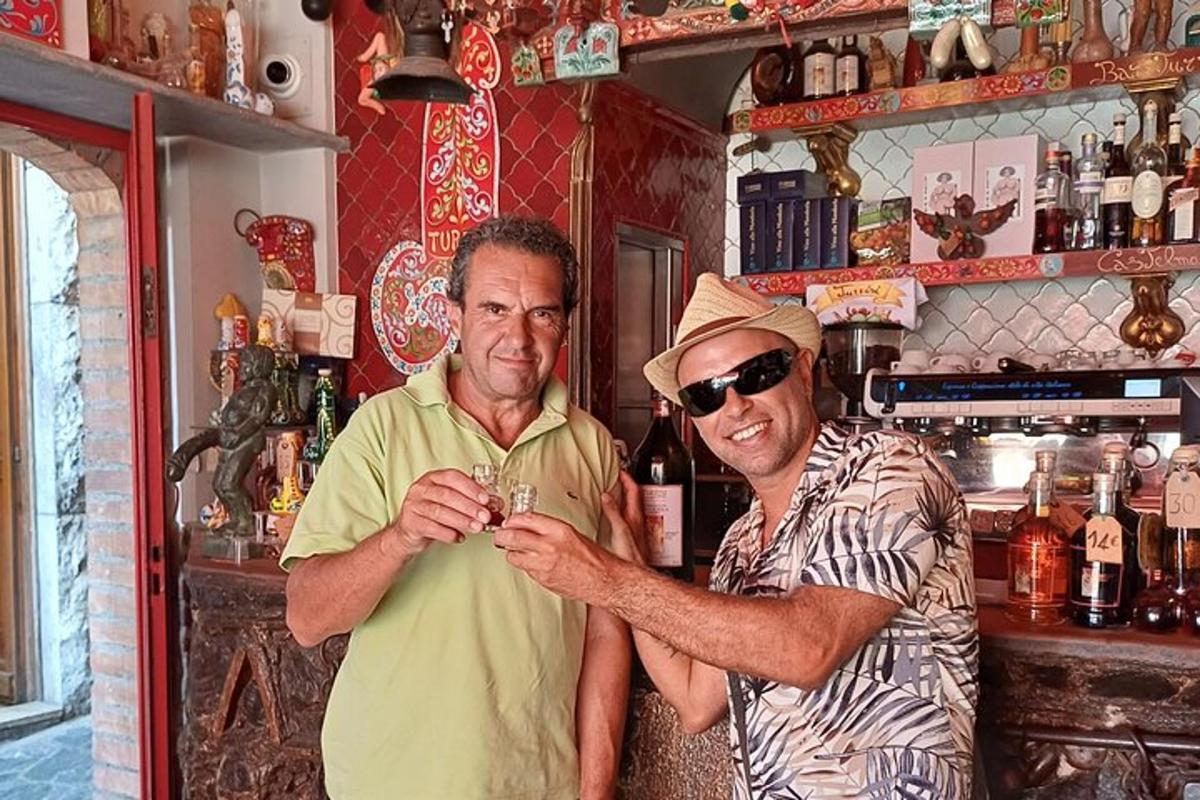 Δύο άντρες στέκονται σε ένα μπαρ κρατώντας ένα ποτήρι