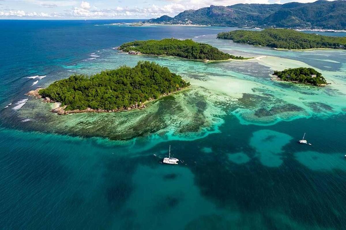 an island in the ocean with two boats in the water