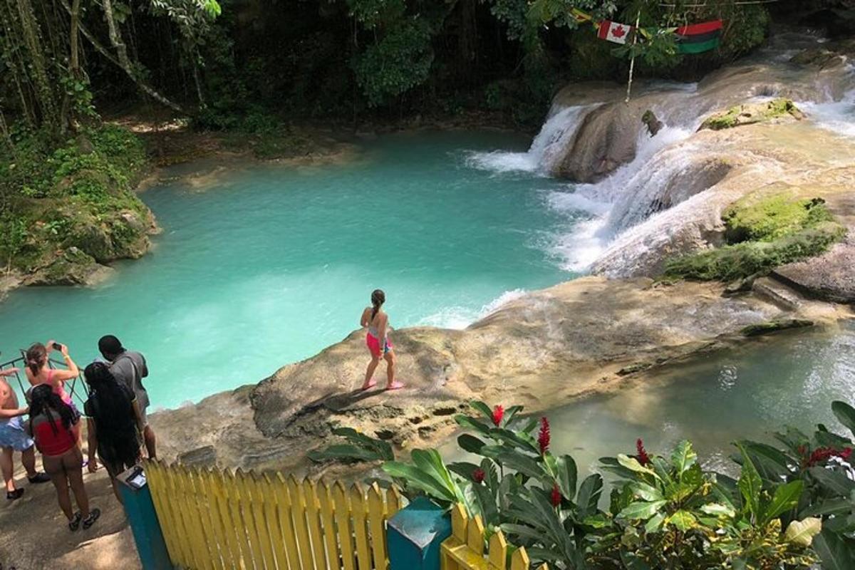 un gruppo di persone in piedi su una roccia vicino a una cascata