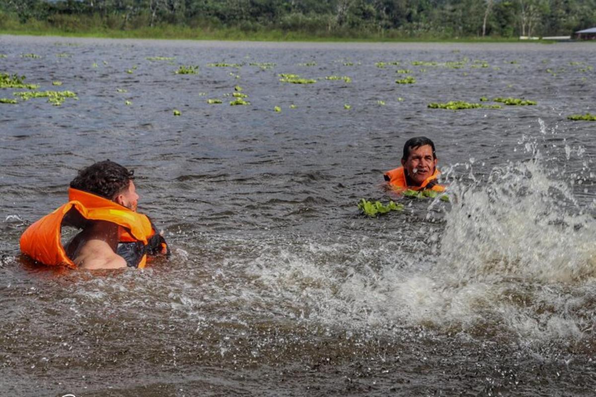 Dos personas en un lago con chalecos salvavidas