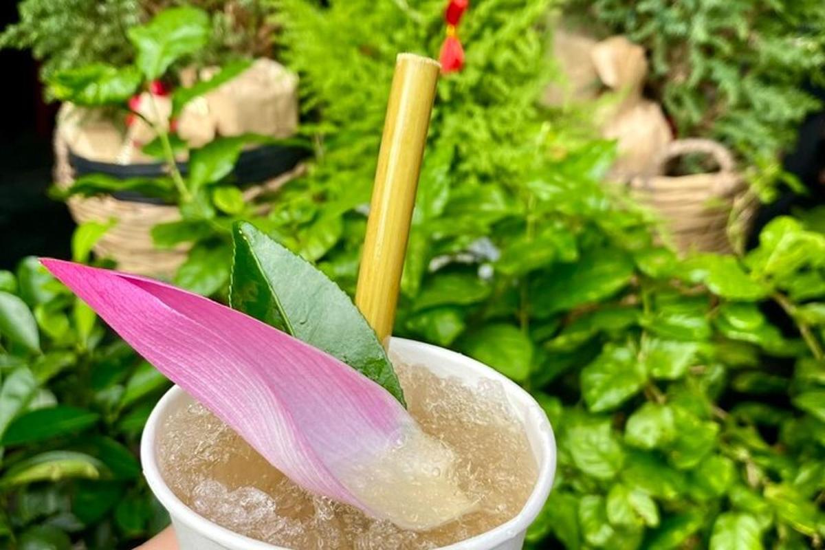 một bông hoa màu hồng trong một thức uống trong cốc
