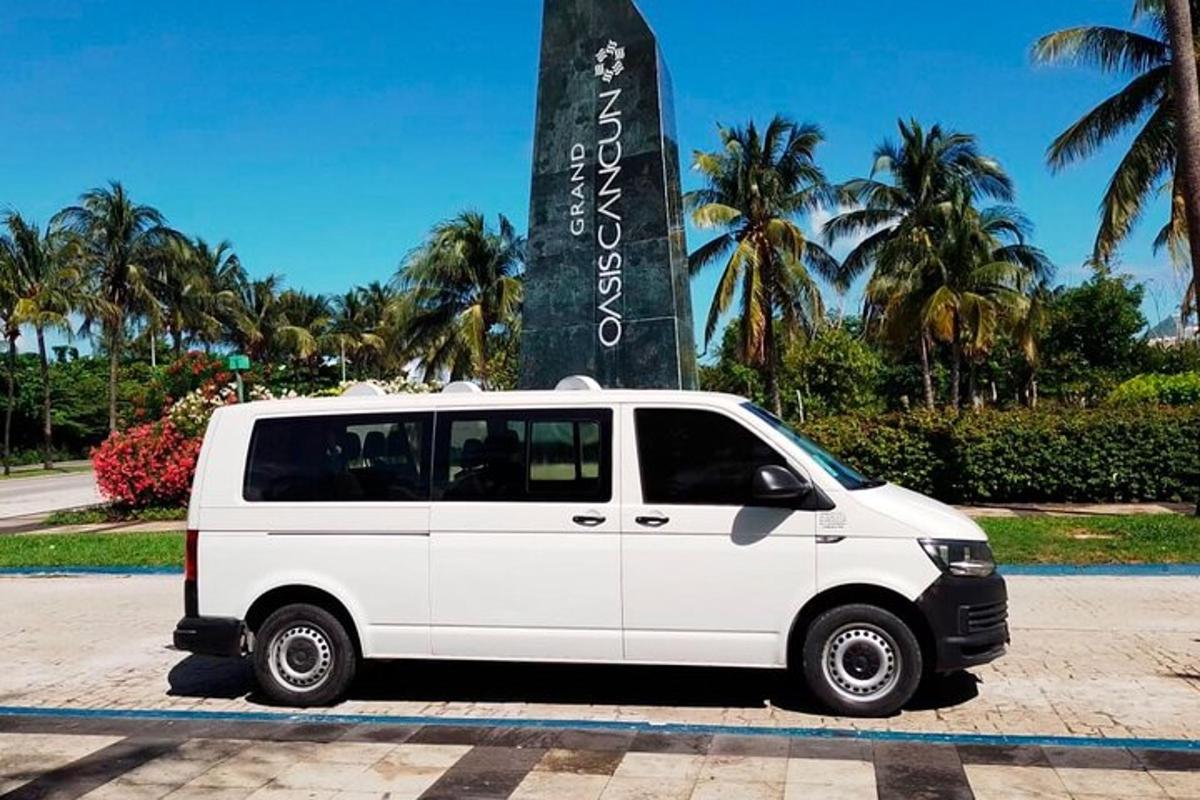 Una camioneta blanca estacionada frente a un cartel