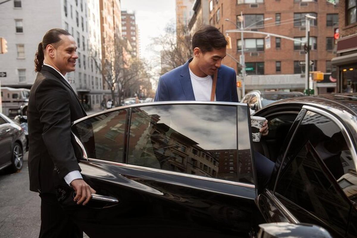 dois homens estão parados ao lado de um carro