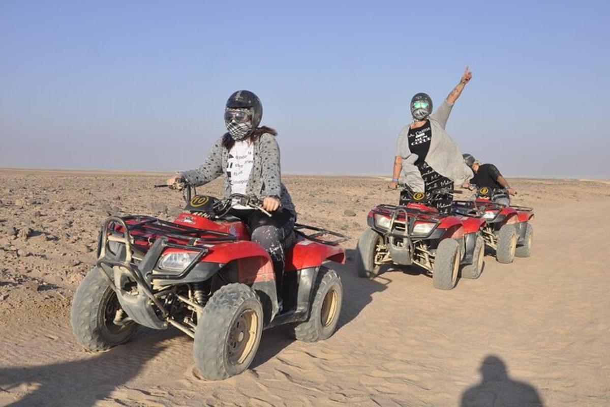 sekumpulan orang menunggang atv di padang pasir
