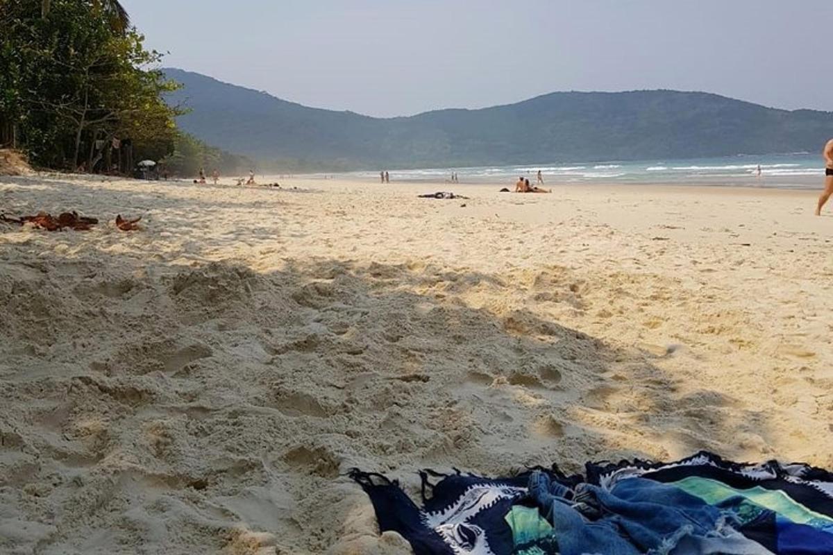 egy strand, ahol egy törölköző fekszik a homokban
