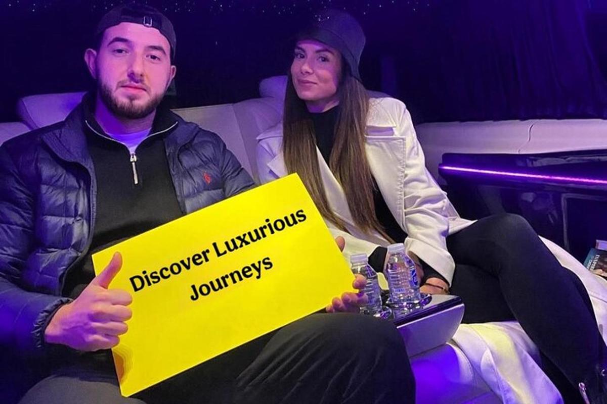 a man and a woman sitting on a couch holding a yellow sign