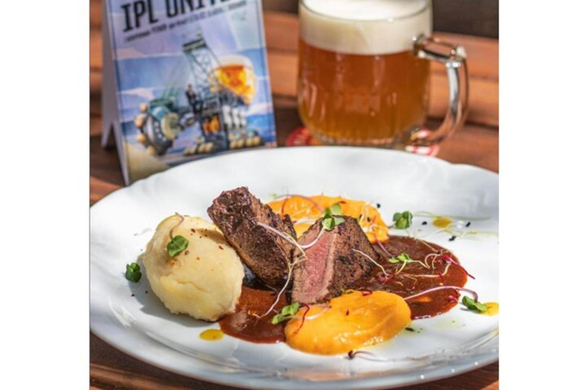 un plat de menjar sobre una taula amb una gerra de cervesa