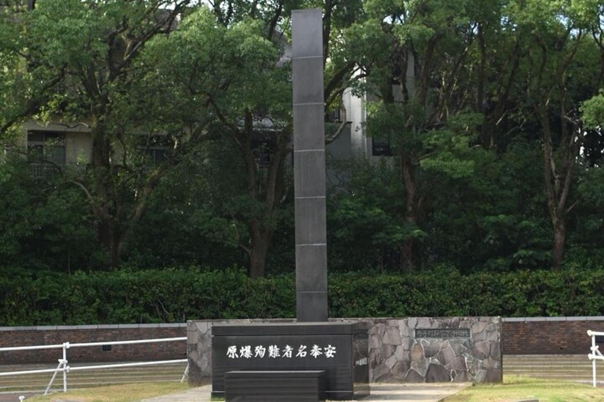 a pole with a monument in a park with trees