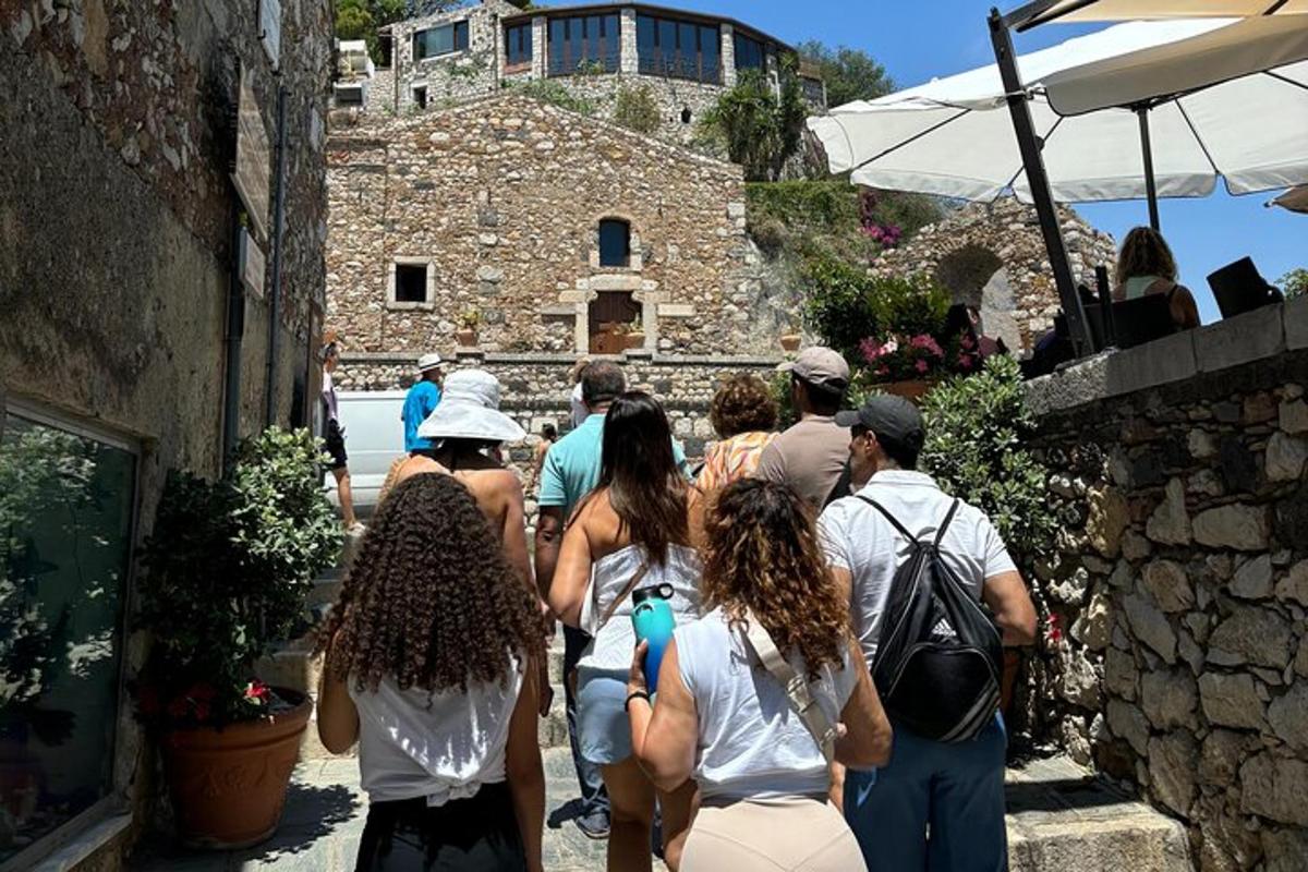 un grupo de personas caminando por un callejón de piedra
