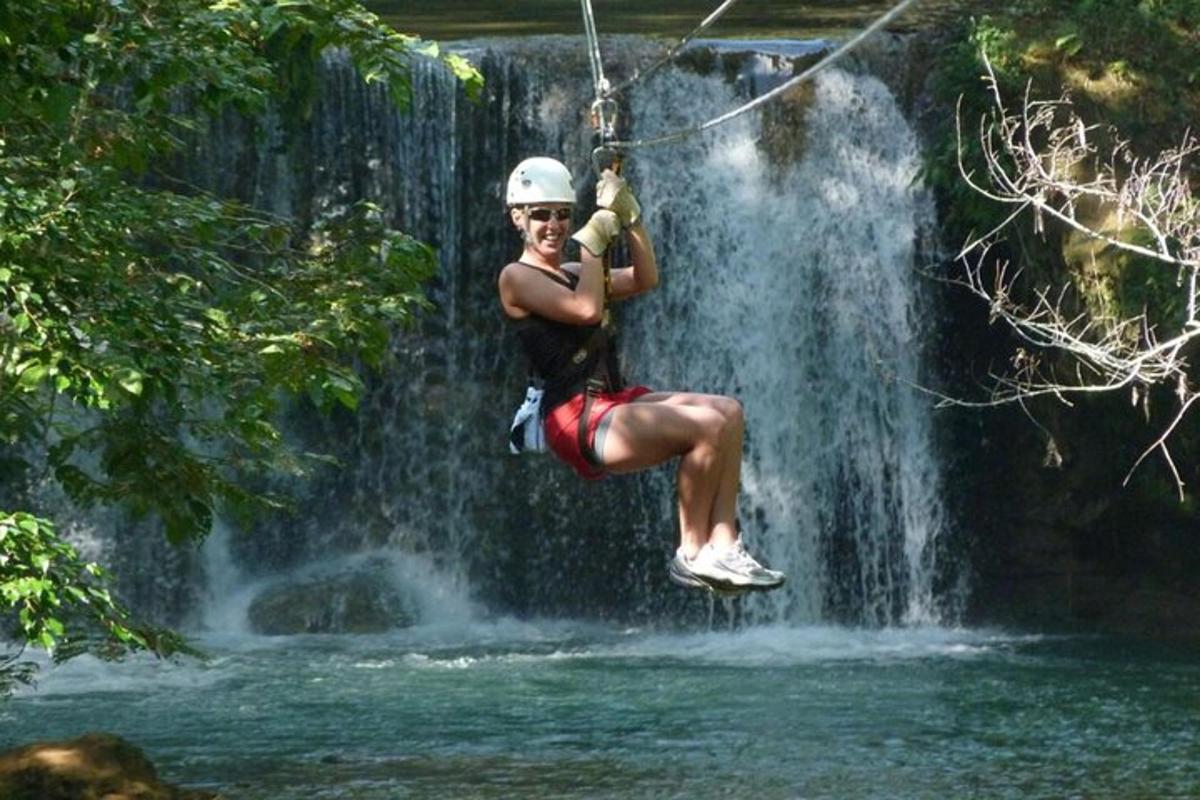 osoba na zip line před vodopádem