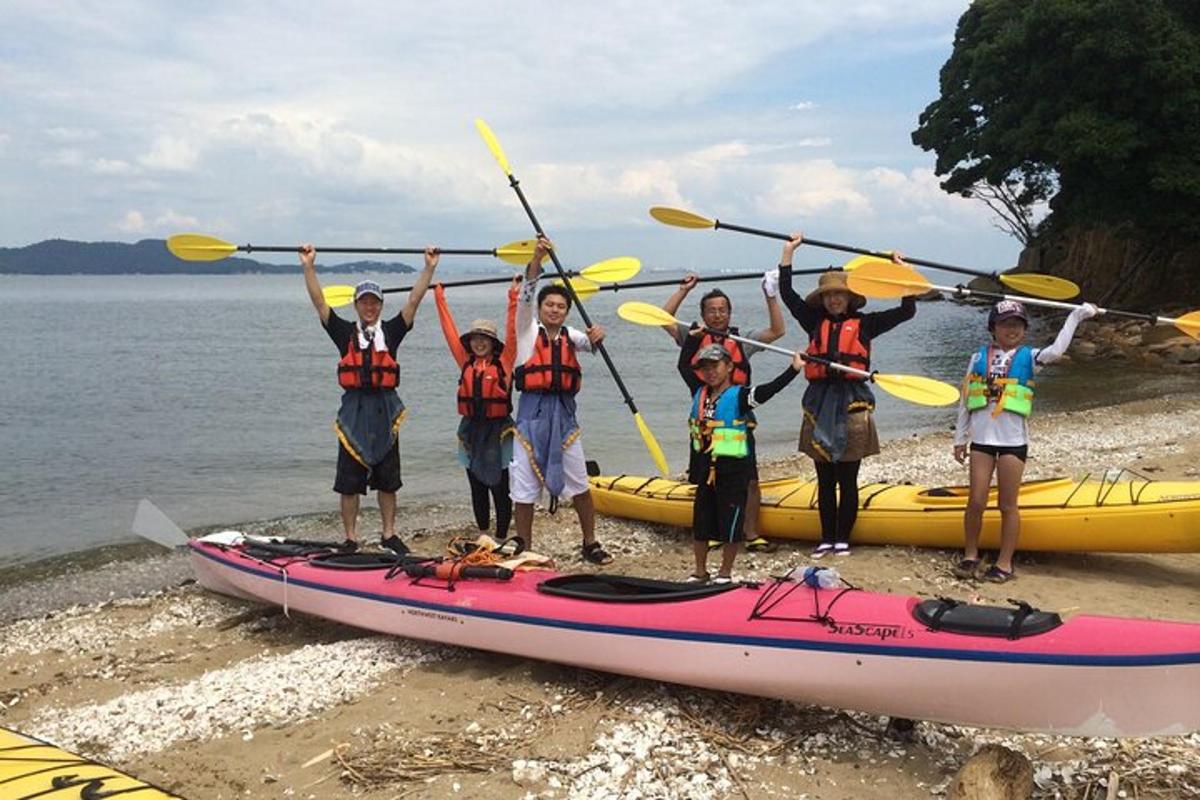 a group of people standing next to a kayak