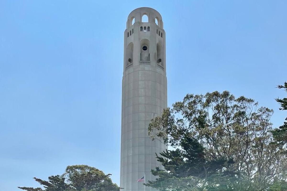 un'alta torre bianca con alberi di fronte