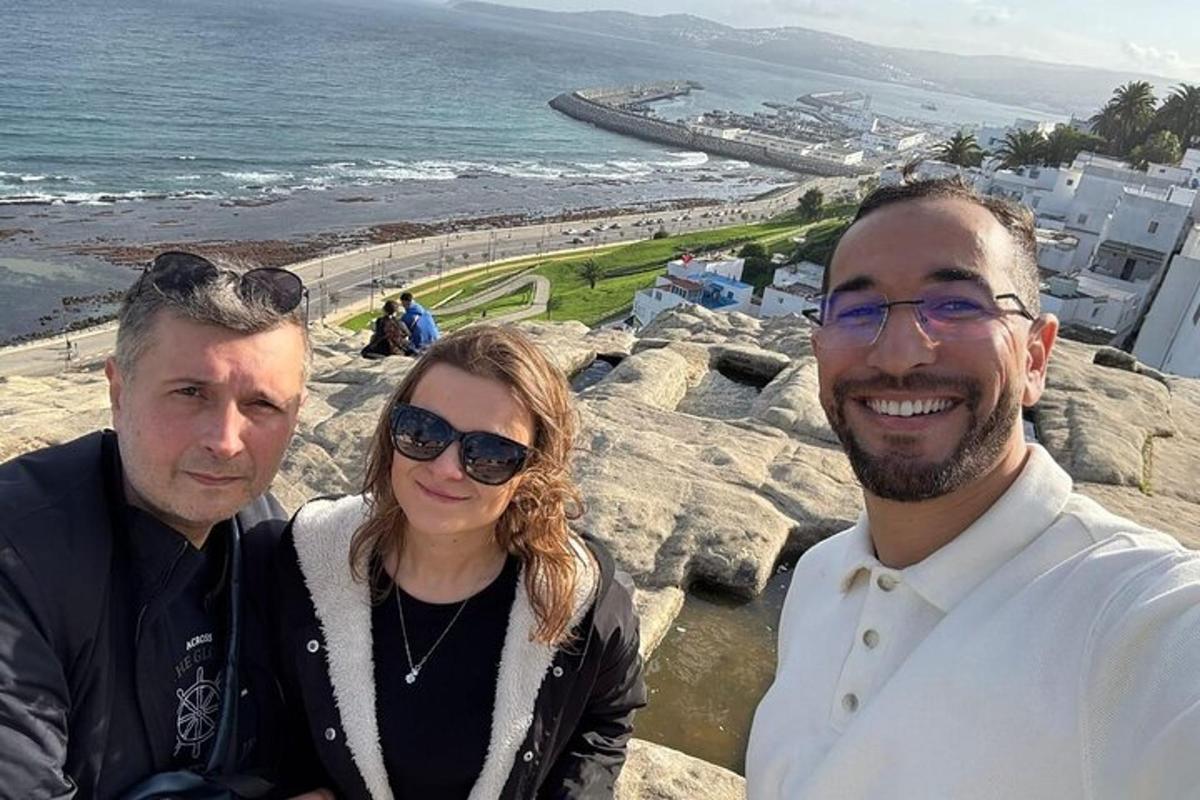 dva muži a žena stojící vedle oceánu