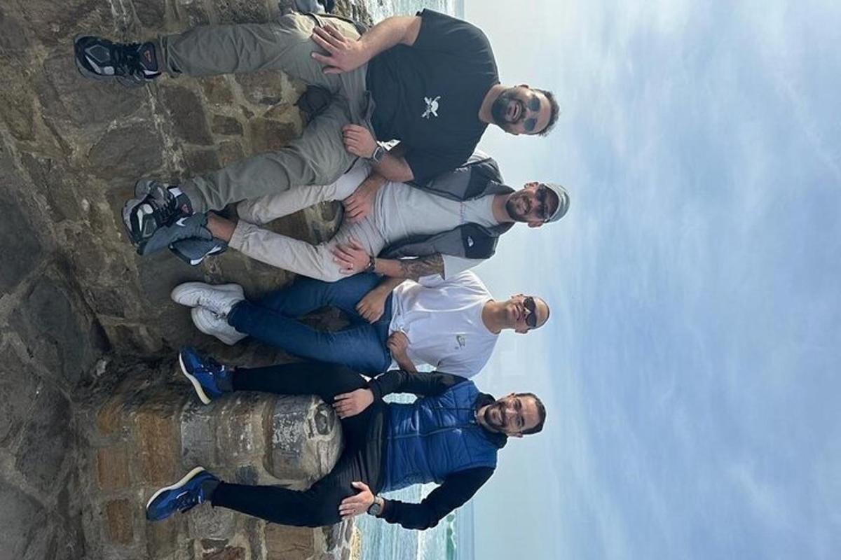 un grup d'homes drets al costat d'una paret