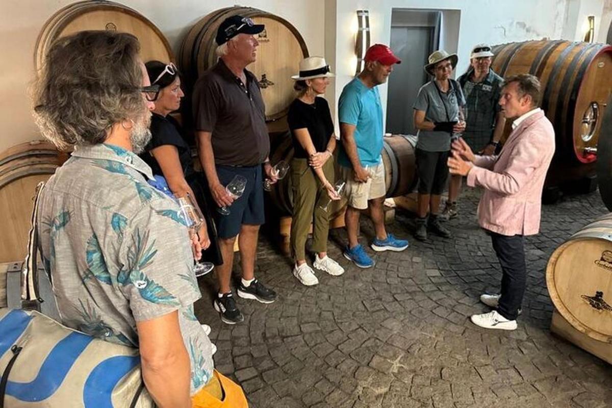un gruppo di persone in piedi in una cantina vinicola