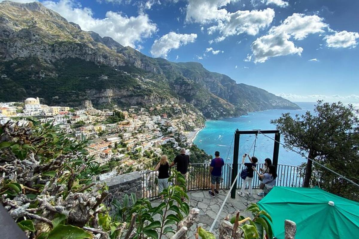 un gruppo di persone in piedi su una sporgenza che guarda l'oceano