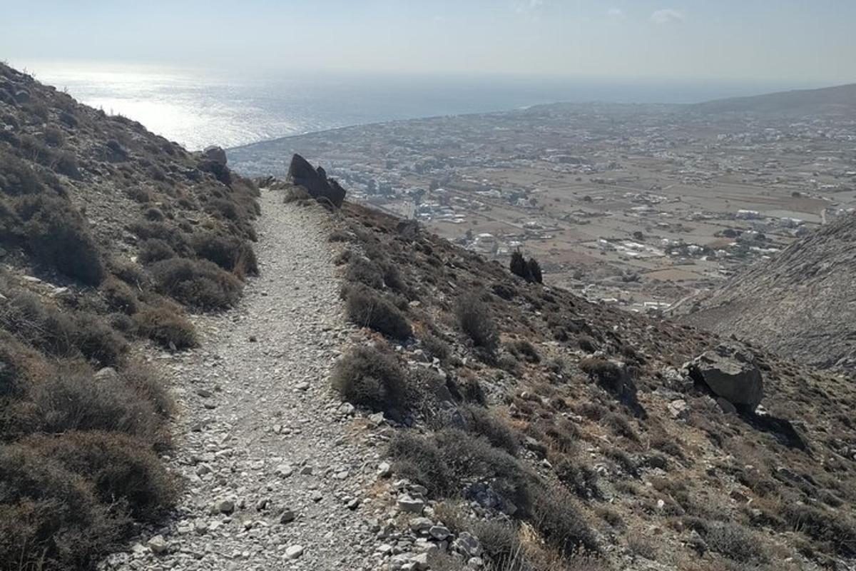 a dirt trail on a hill with the ocean