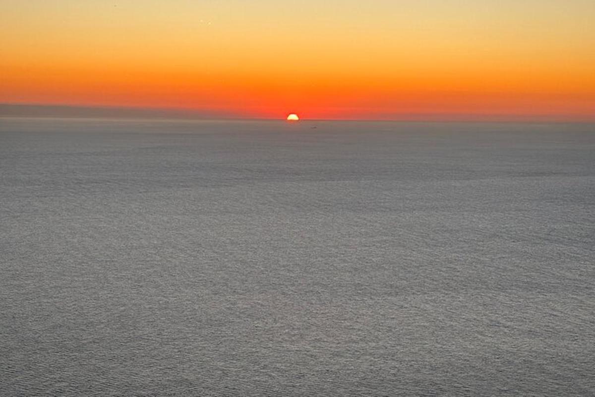 sončni zahod nad oceanom s soncem v daljavi