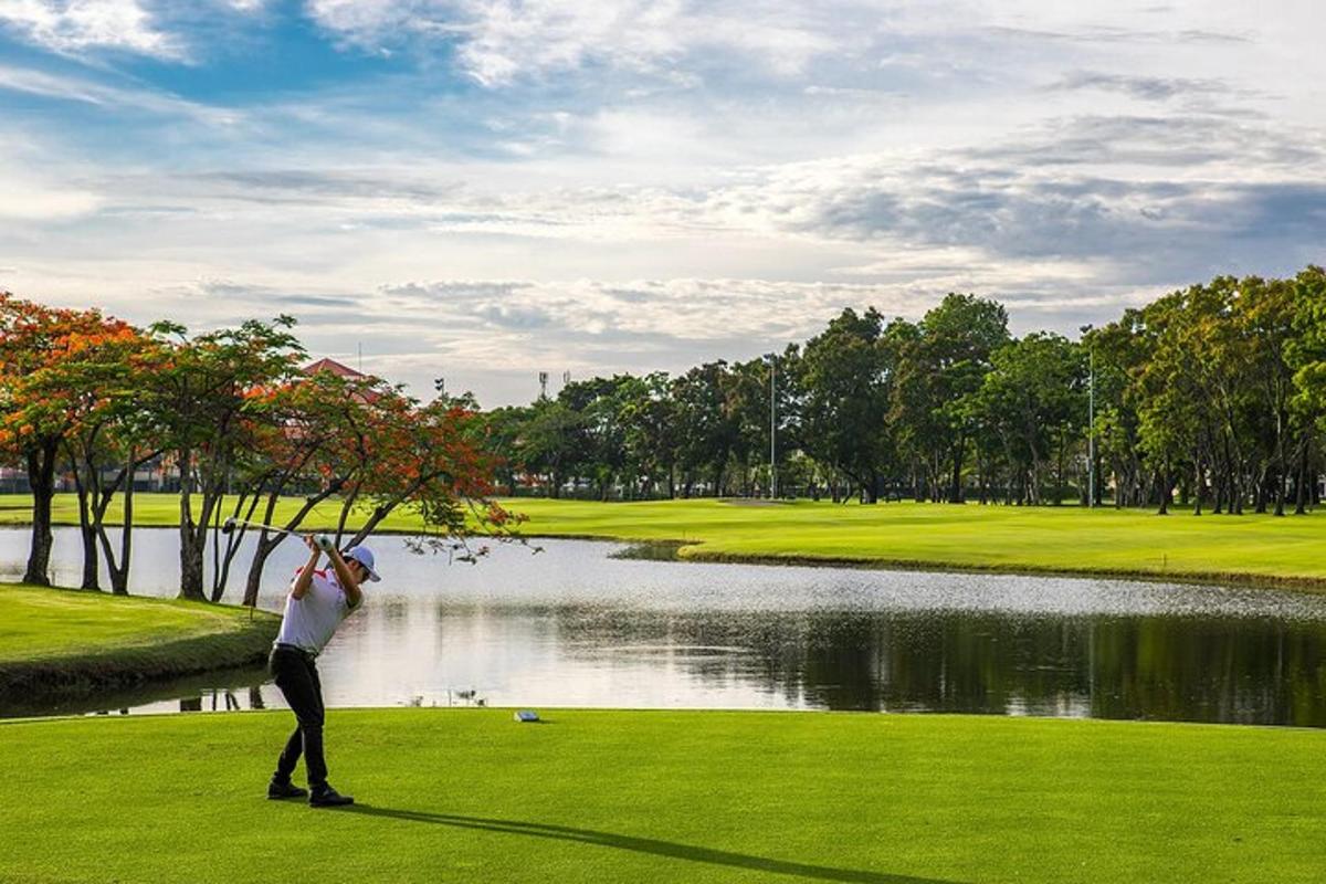 muž stojící na golfovém hřišti poblíž jezera