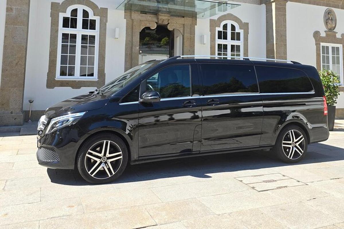 uma van preta estacionada em frente a um prédio