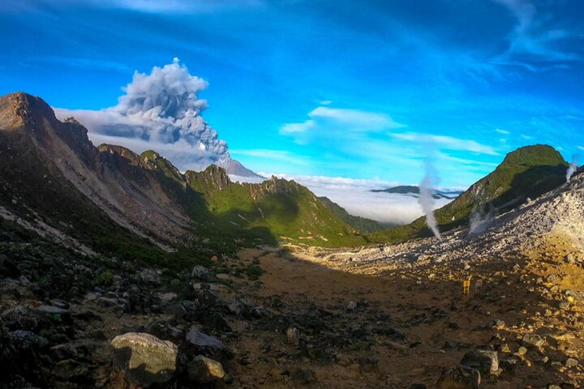 a view of a mountain range with clouds in the background