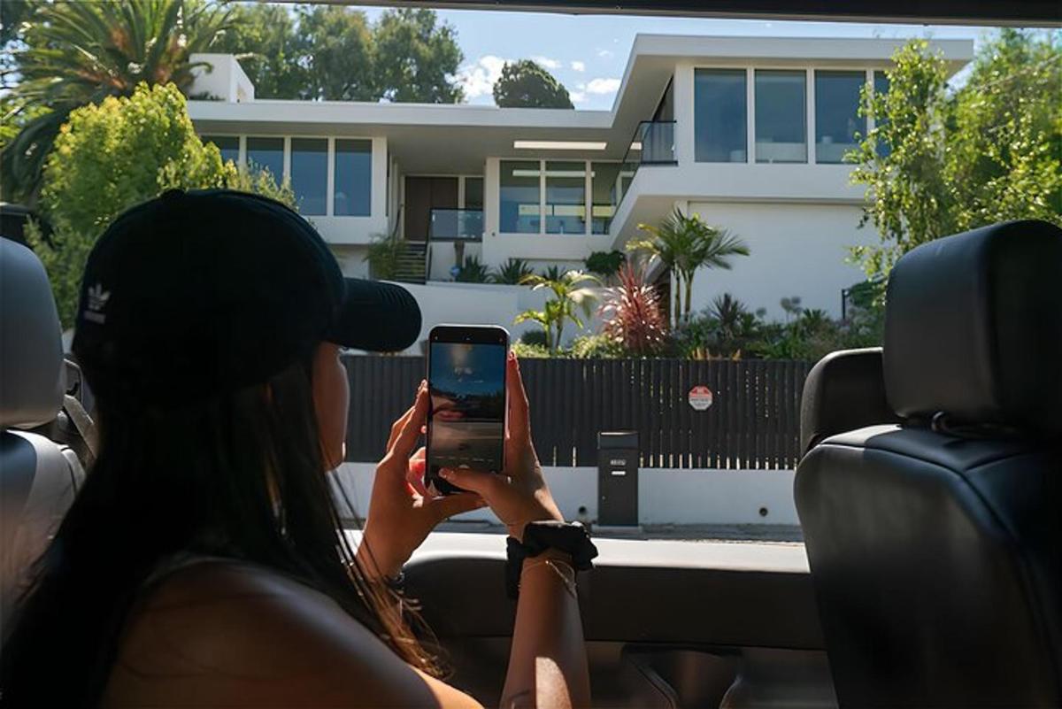 a woman sitting in a car looking at a cell phone