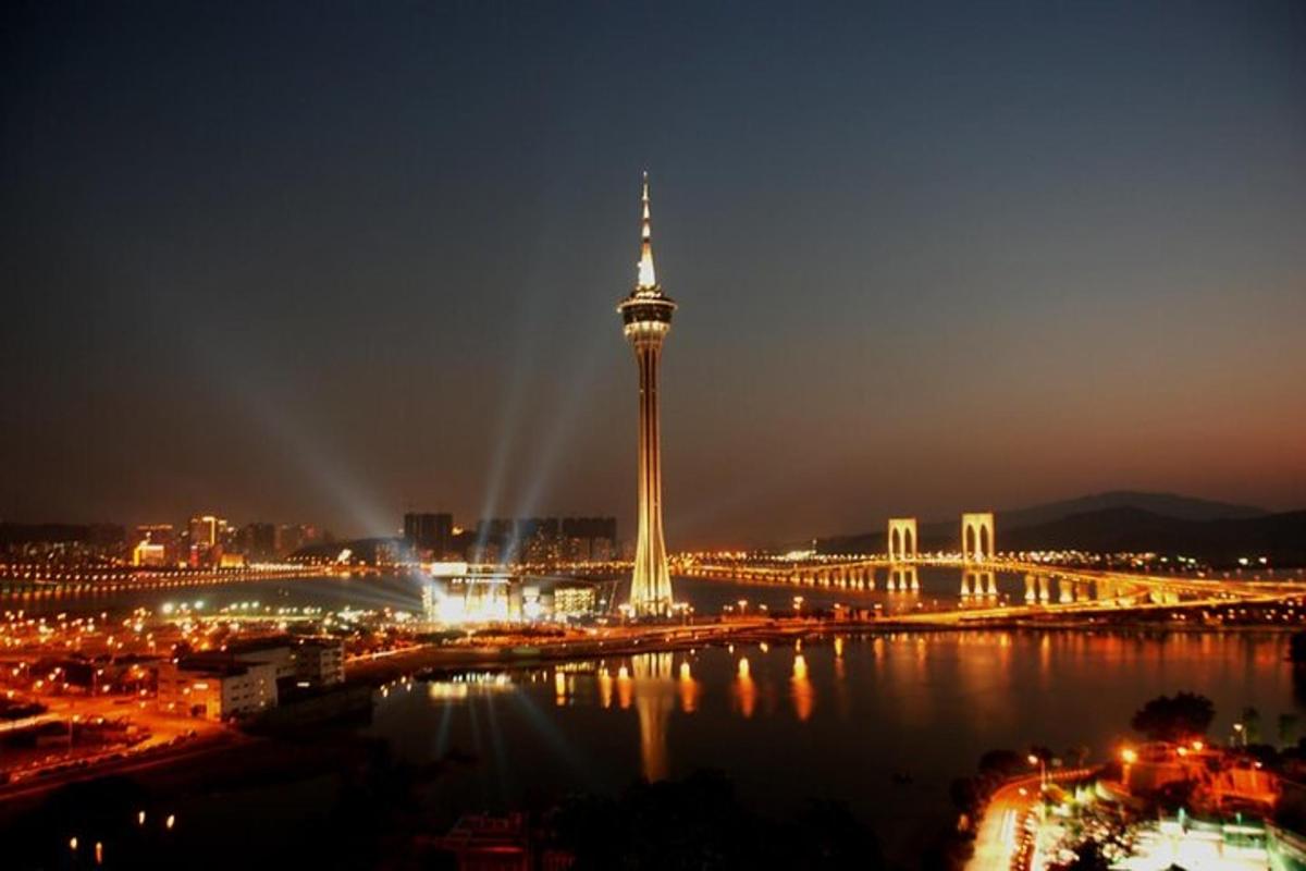 uma vista de uma cidade com uma torre à noite