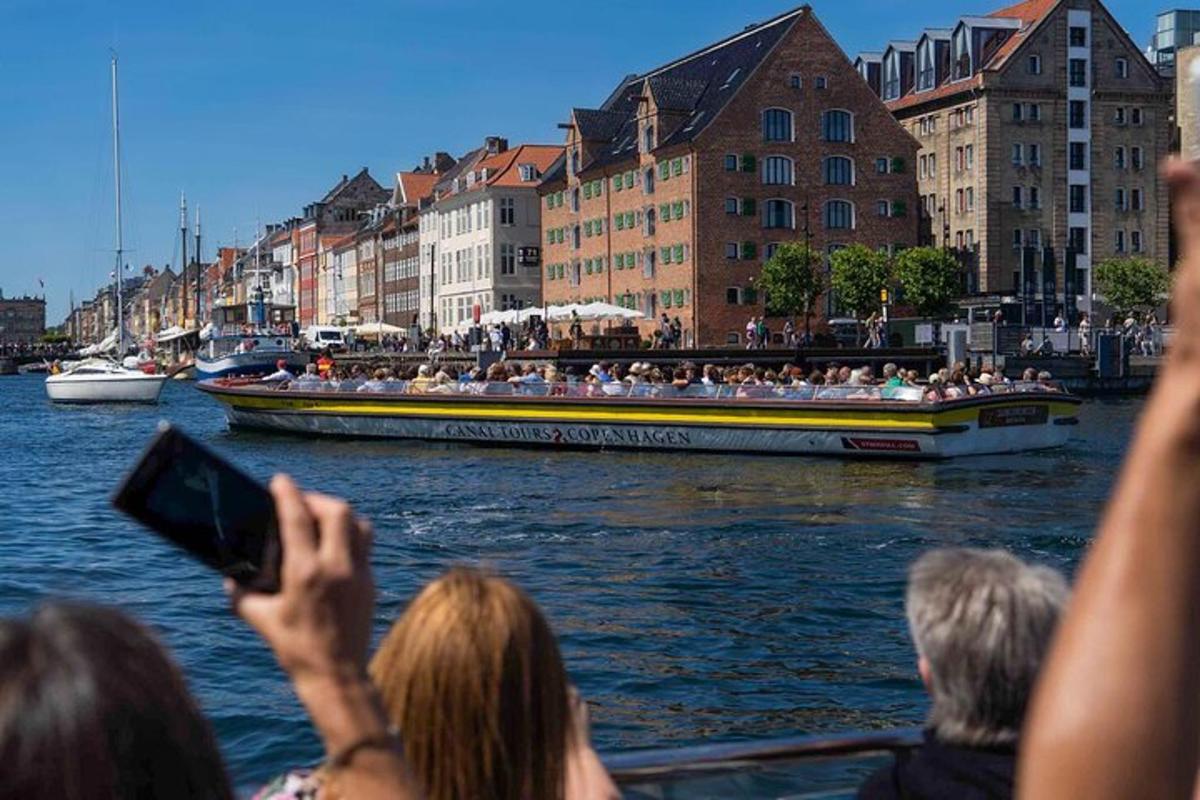 un gruppo di persone che scatta foto di una barca in acqua