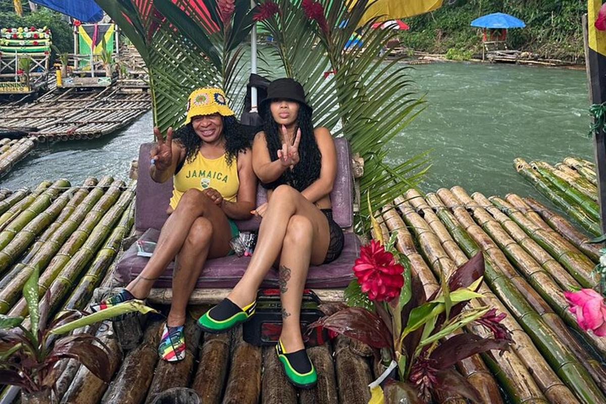 two women sitting on a chair next to a river