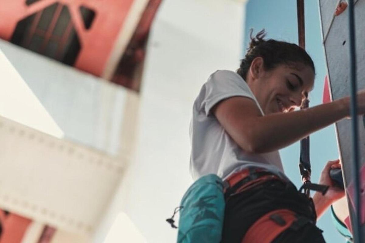 una ragazza sta scalando una parete da arrampicata